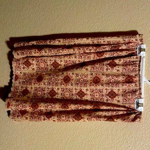 Cream skirt with red, pink, and brown designs. Size Medium. Pencil skirt style.